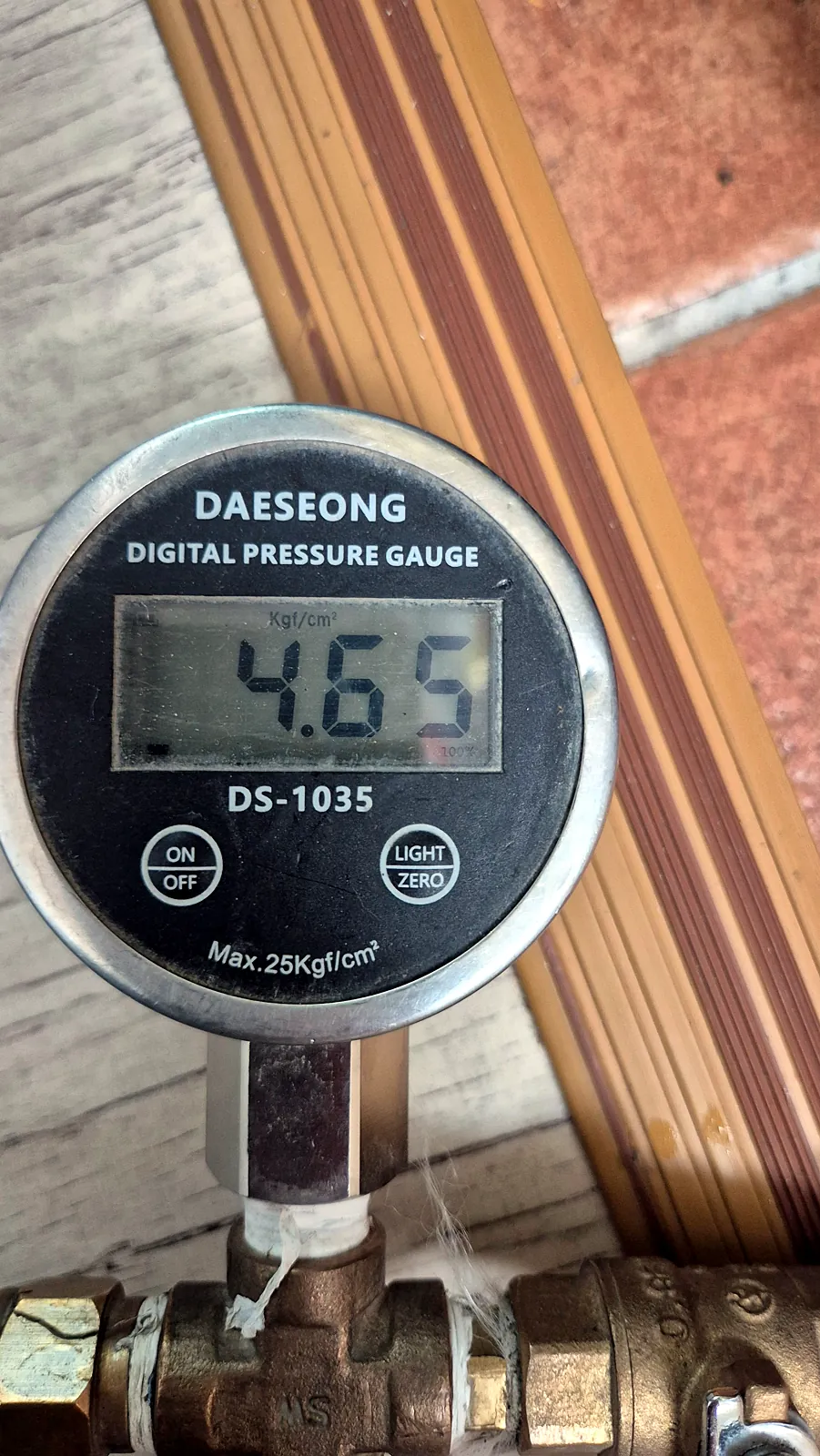 급수 배관에 물린 디지털 압력계가 4.65kgf/cm²를 표시한 모습