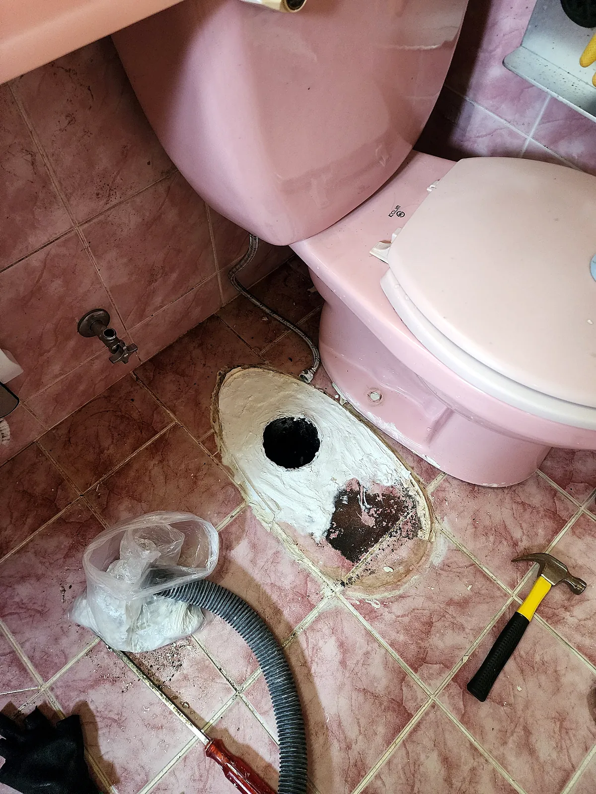 변기를 떼어 낸 바닥 배수구 둘레에 흰색 방수재를 바른 모습