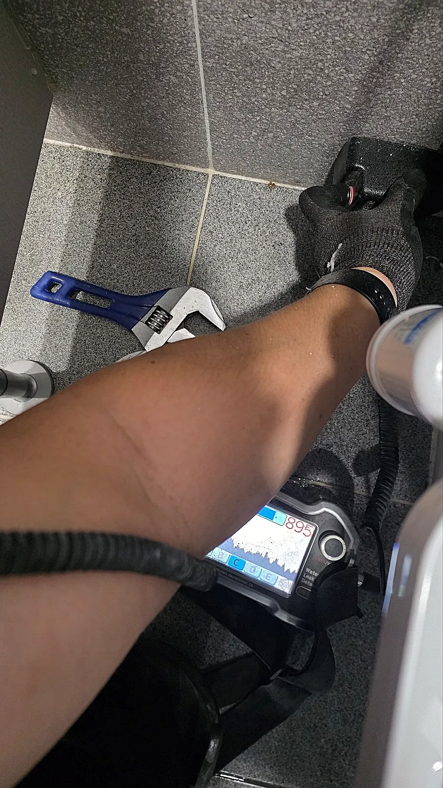 누수탐지: 청음식 누수탐지기로 벽 하단을 짚어 새는 소리를 듣는 기사